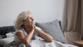 Peaceful middle aged woman welcoming new day in bedroom.