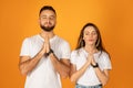 Peaceful young man and woman with eyes closed, hands pressed together in a prayer or meditative pose Royalty Free Stock Photo