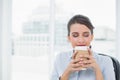 Peaceful classy brown haired businesswoman enjoying coffee smell