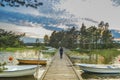 Peaceful cloud landscape enjoyed by lonely woman tourist in wooden pathway through the lake water and water reflection of
