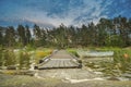 Peaceful cloud landscape on wooden pathway through the lake water and water reflection of stadinding cannoe during the sunset