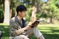 Peaceful college student reading book, relaxing on campus lawn. Education and lifestyle concept Royalty Free Stock Photo