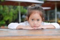 Peaceful Cute little Asian child girl lying on the wooden table with looking you Royalty Free Stock Photo