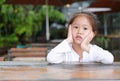 Peaceful Cute little Asian child girl lying on the wooden table with looking you Royalty Free Stock Photo