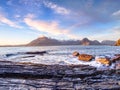 Peaceful dawn at Elgol bay. Low angle overlooking of offshore rocks and smooth sea, mountains Royalty Free Stock Photo