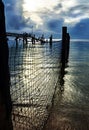 Peaceful day ends sun setting over fishing nets wharf & sea Royalty Free Stock Photo