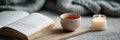 Peaceful Desk Setup With Cup of Tea, Open Book, and Candle Creating a Serene Atmosphere for Relaxation or Study Royalty Free Stock Photo