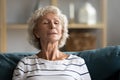 Peaceful elderly woman rest on couch taking nap Royalty Free Stock Photo