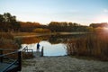 Peaceful fishing on the lake in autumn evening.