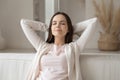 Peaceful girl with closed eyes resting on comfortable couch