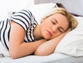 Girl sleeping with striped pygamas in bed