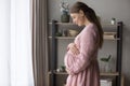 Peaceful happy expecting mom wearing stylish linen dress Royalty Free Stock Photo