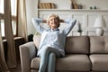 Peaceful happy grey-haired old woman relaxing on couch at home Royalty Free Stock Photo