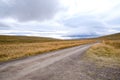 A peaceful idyllic landscape Landscape of Blondus, blue/white sky, grass, a long empty dirt road in pretty autumn colours in Icela Royalty Free Stock Photo