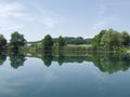 Peaceful lake with clouds and trees reflected in water Royalty Free Stock Photo