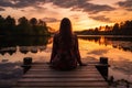 Peaceful lifestyle shot of woman sitting on dock at sunset on Lake