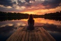 Peaceful lifestyle shot of woman sitting on dock at sunset on Lake