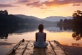 Peaceful lifestyle shot of woman sitting on dock at sunset on Lake