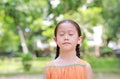 Peaceful little Asian child girl close their eyes in garden with Breathe fresh air from nature. Portrait of kid relax in green Royalty Free Stock Photo