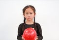 Peaceful little Asian child girl holding round silicone inflatable red knobby ball on white background