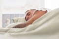 Peaceful man with tattoo on arm sleeping in bed in morning