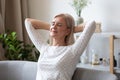 Peaceful middle aged pleasant woman daydreaming on comfortable sofa. Royalty Free Stock Photo