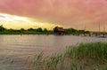 Peaceful nature at the Lake FertÃâ in Hungary with wooden pier bungalows cabins on the lake and straw in the water at