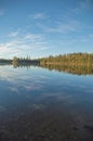 Peaceful Northern Ontario lake in early morning with reflected c Royalty Free Stock Photo
