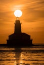 Peaceful orange and yellow sunset over a lighthouse in Chicago, with the sun setting on the horizon Royalty Free Stock Photo