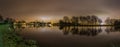 Peaceful panoramic view of river and trees backlit by Amsterdam city lights