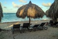 Peaceful place with palm trees and cabanas with chairs over white sand beach Royalty Free Stock Photo