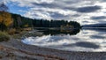 Peaceful and quiet scenery of lake with dramatic clouds reflected in the calm water and autumn trees around Royalty Free Stock Photo