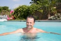 Peaceful relax man floating in swimming pool summer day