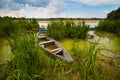 Peaceful rural landscape with little colorful wooden craft fishing boats or punts at a lake shore in rich green vegetation Royalty Free Stock Photo