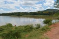 Peaceful scenery of Kamuzu Dam in Lilongwe, Malawi in Africa. African woman is taking water from the lake, surrounded by hills, Royalty Free Stock Photo