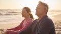 Peaceful Senior Couple Relaxing Sitting On Beach Shoreline With Closed Eyes At Sunrise Together Royalty Free Stock Photo