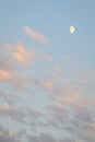 Peaceful sky at dusk, light clouds and partial moon, as a nature background