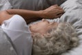 Peaceful sleepy elderly lady resting in linen bedding