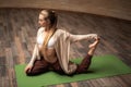 Calm lady closing her eyes while stretching on the yoga mat