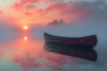 The peaceful solitude of a canoe on a misty lake at dawn Royalty Free Stock Photo