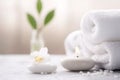 A peaceful spa setting with a white towel, candle and flower, promoting relaxation and wellness through healthful therapy