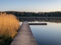 Peaceful spring landscape with a wooden footbridge in the lake, empty beach in the morning Royalty Free Stock Photo