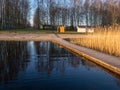 Peaceful spring landscape with a wooden footbridge in the lake, empty beach in the morning Royalty Free Stock Photo