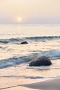 Peaceful sunrise on a beach, selective focus on rock, long exposure picture