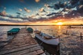 Peaceful sunset with dramatic sky and boats and a jetty Royalty Free Stock Photo