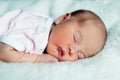 Peaceful sweet newborn infant baby lying on bed while sleeping in a bright room Royalty Free Stock Photo