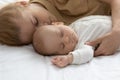 Peaceful tired mother and calm infant sleeping together