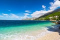 Peaceful and transparent summer sea, mountainous landscape in the background