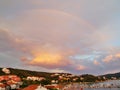 Peaceful view at small croatian village with rainbow and evening light over a small bay with boats Royalty Free Stock Photo