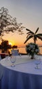 A peaceful view of sunset on a lake coast with romantic dinner table . Royalty Free Stock Photo